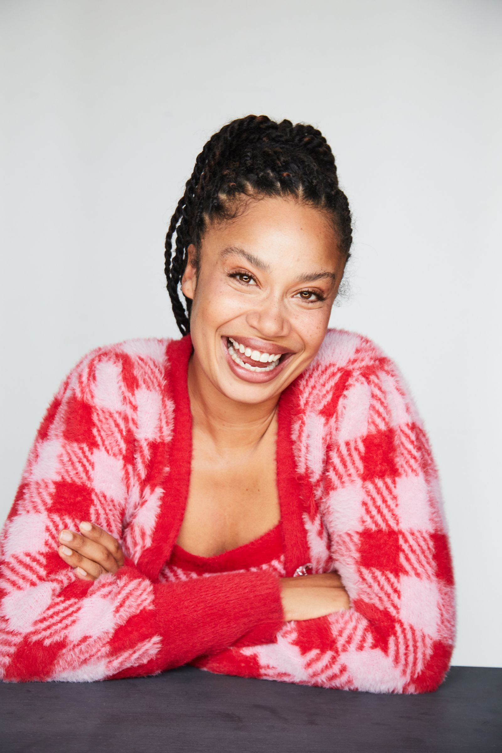 Smiling person in red and pink checkered sweater.