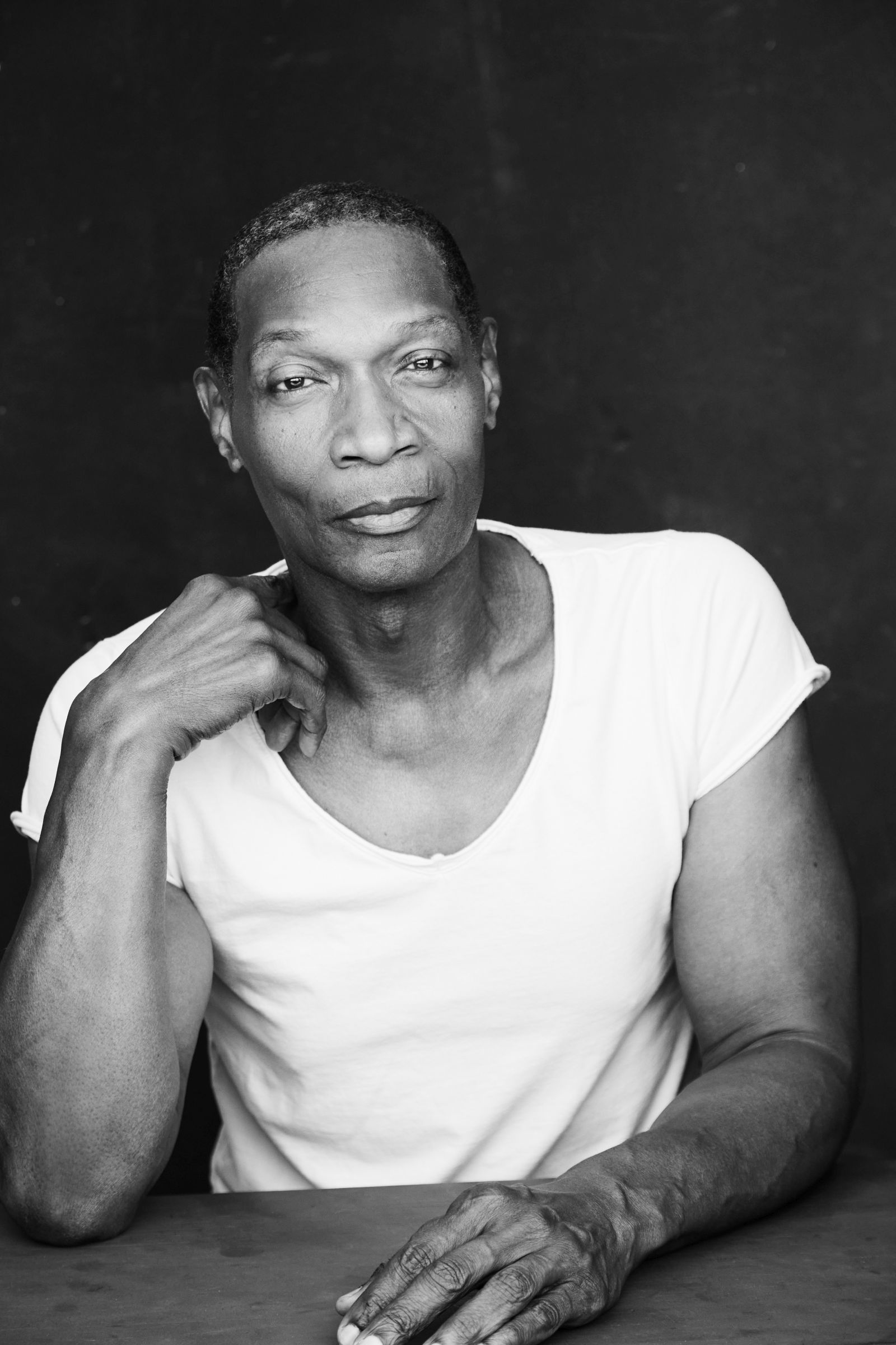 Man in a white shirt with a contemplative expression.